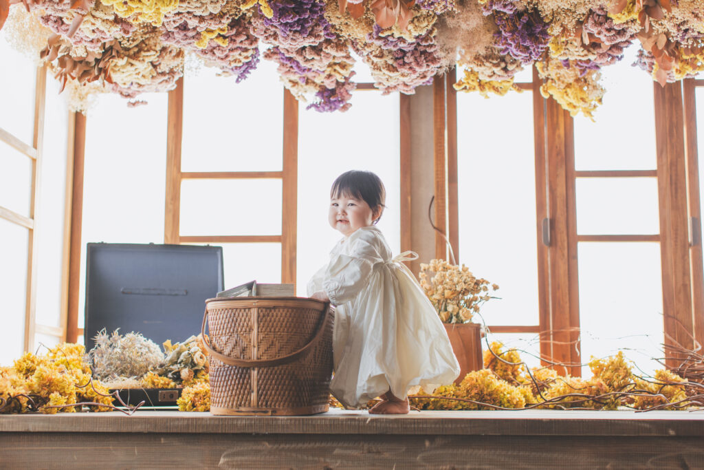 ドライフラワーに囲まれた1歳バースデーフォトの女の子