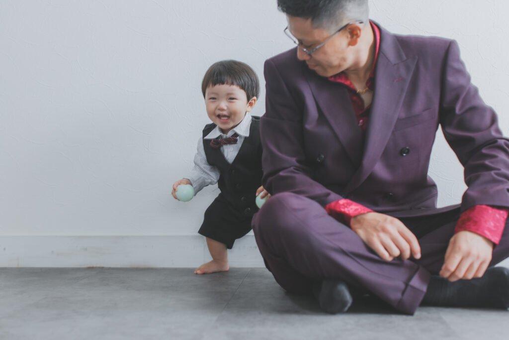 栃木県の写真スタジオでパパの背中に隠れる1歳男の子