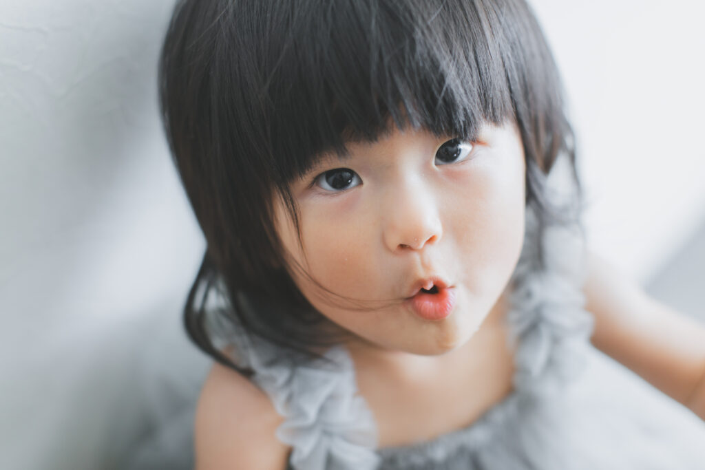 バースデーフォトで口をとんがらせる1歳女の子の写真