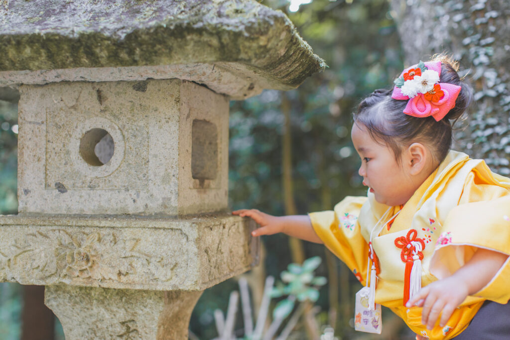 灯篭を覗き込む七五三の3歳女の子(太平山神社ロケーションフォト)