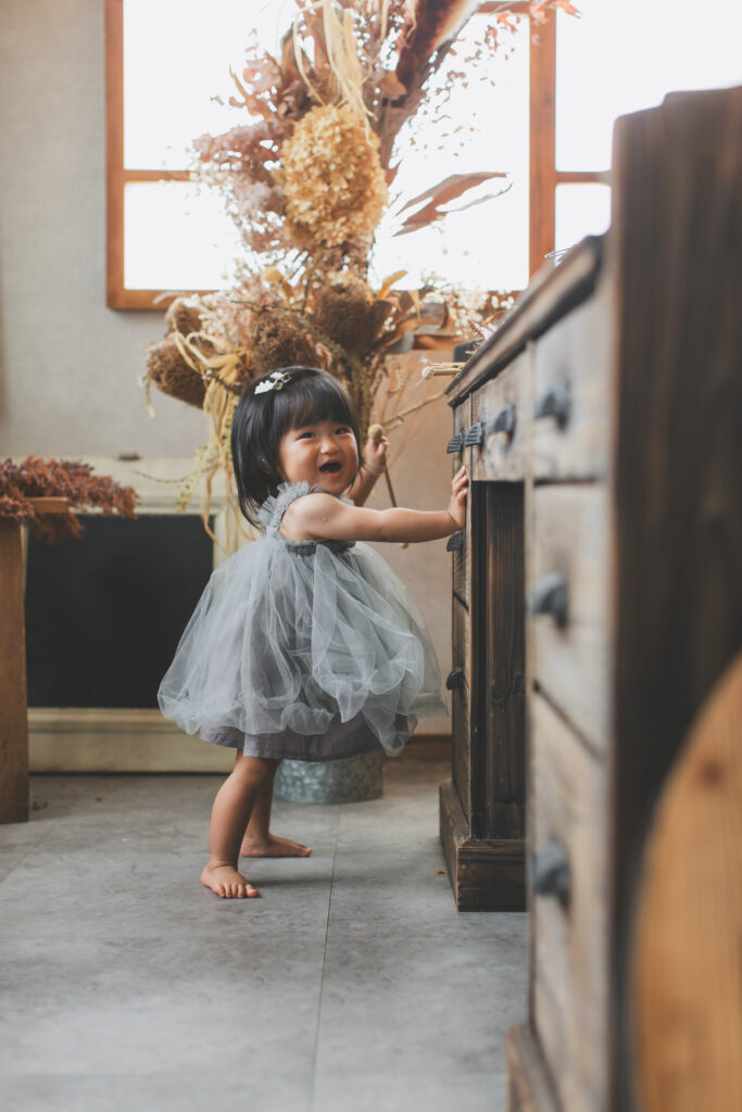 小山市の写真スタジオでつかまり立ちをする1歳女の子