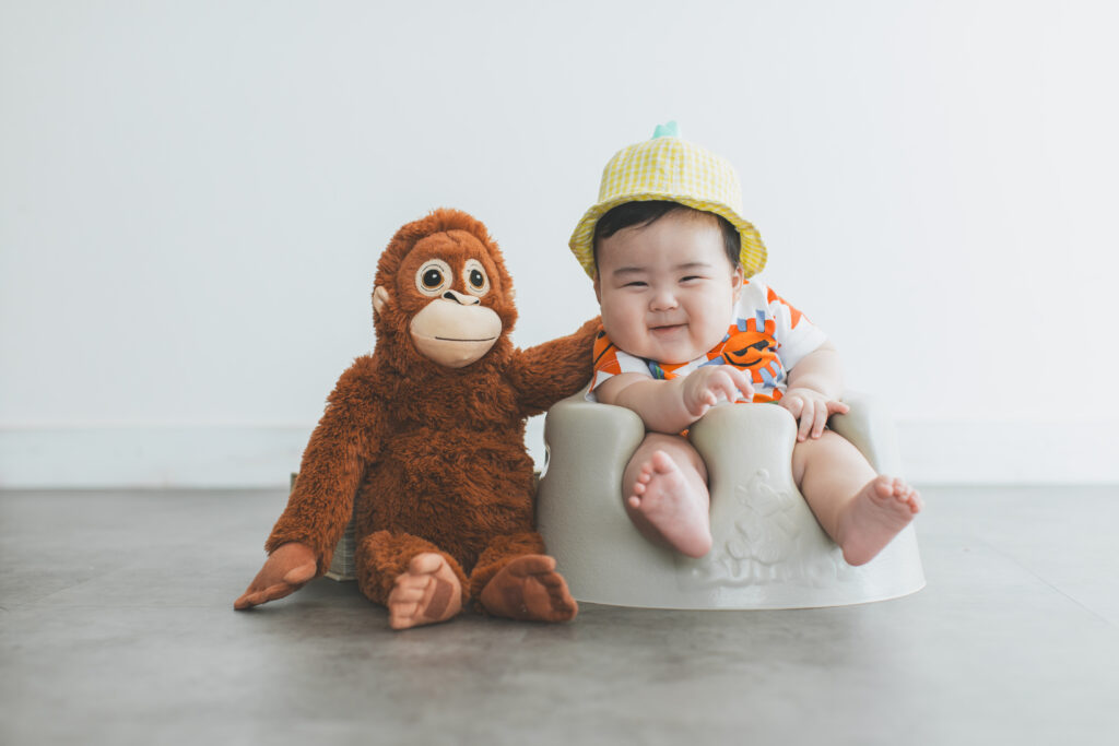 フォトスタジオでお気に入りのぬいぐるみと撮影する赤ちゃんのお宮参りフォト