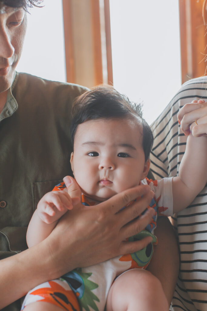 パパにほっぺをむぎゅっとされても無反応の4ヶ月男の子のお宮参り写真