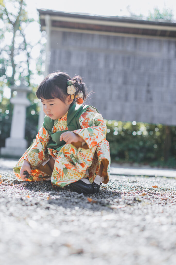 石を拾って見せてくれる元気な七五三の姿