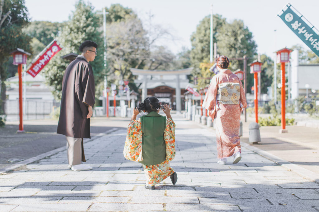 鳥居の前で笑顔を見せる3歳の七五三の女の子
