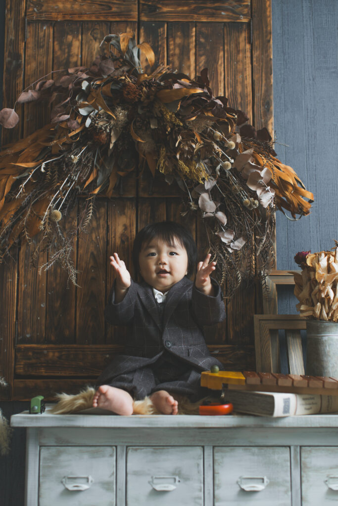 1歳バースデーフォトで手をパチパチして笑う男の子｜小山市フォトスタジオ