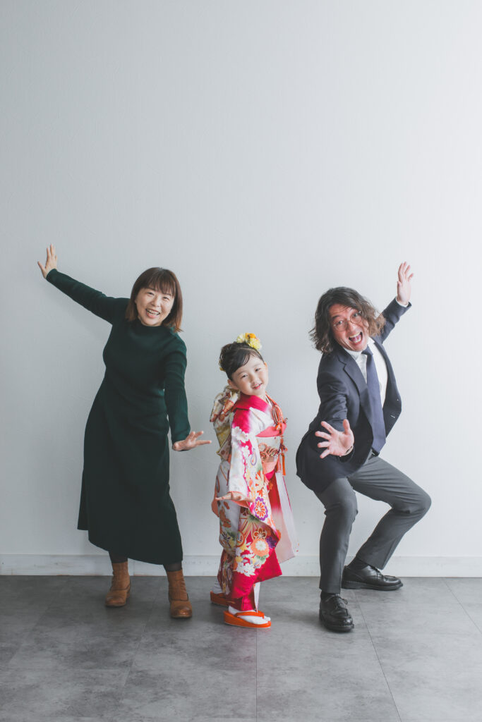 家族ではっちゃけたポーズで笑顔を見せる七五三記念写真