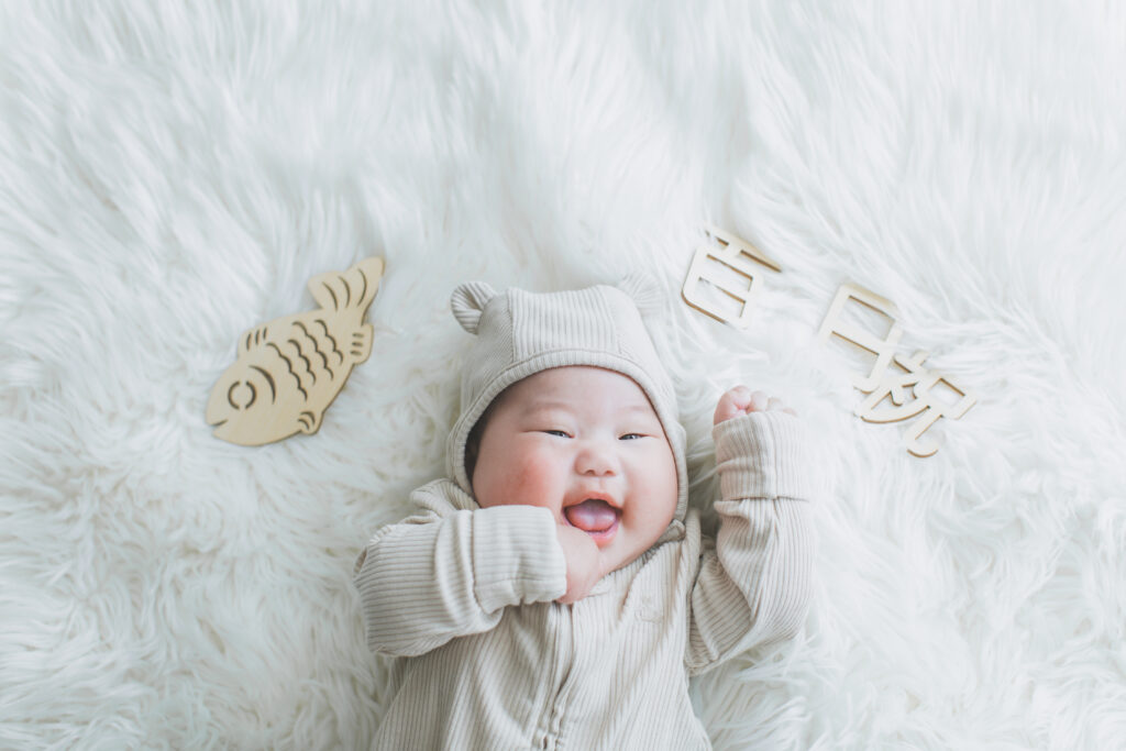 100日祝いで笑顔を見せる赤ちゃん フォトスタジオ