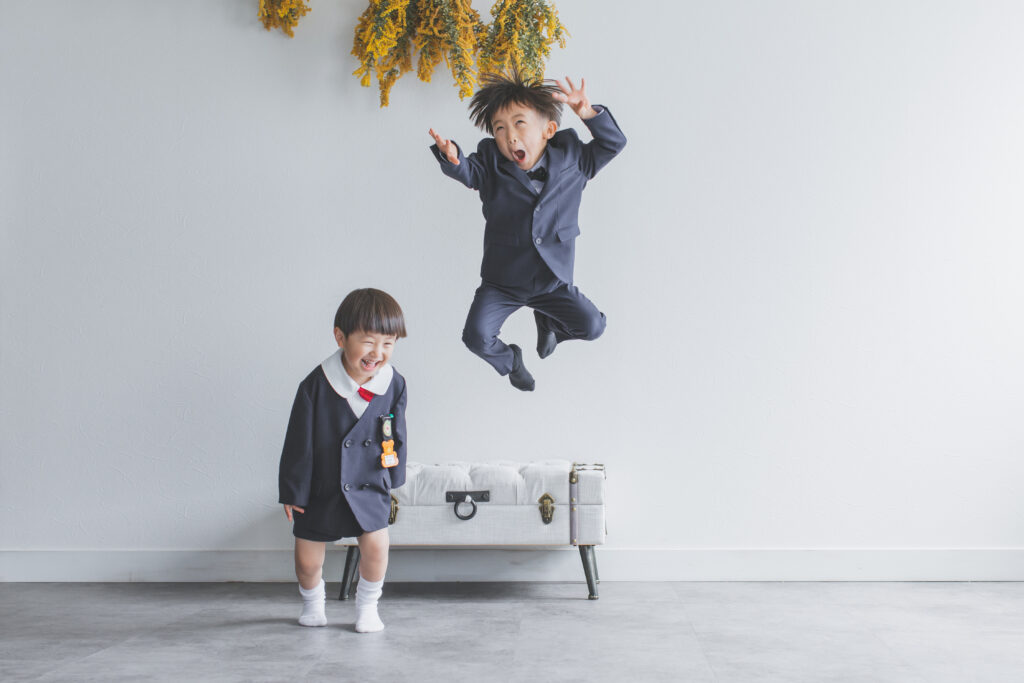 兄弟でジャンプしている自然な写真