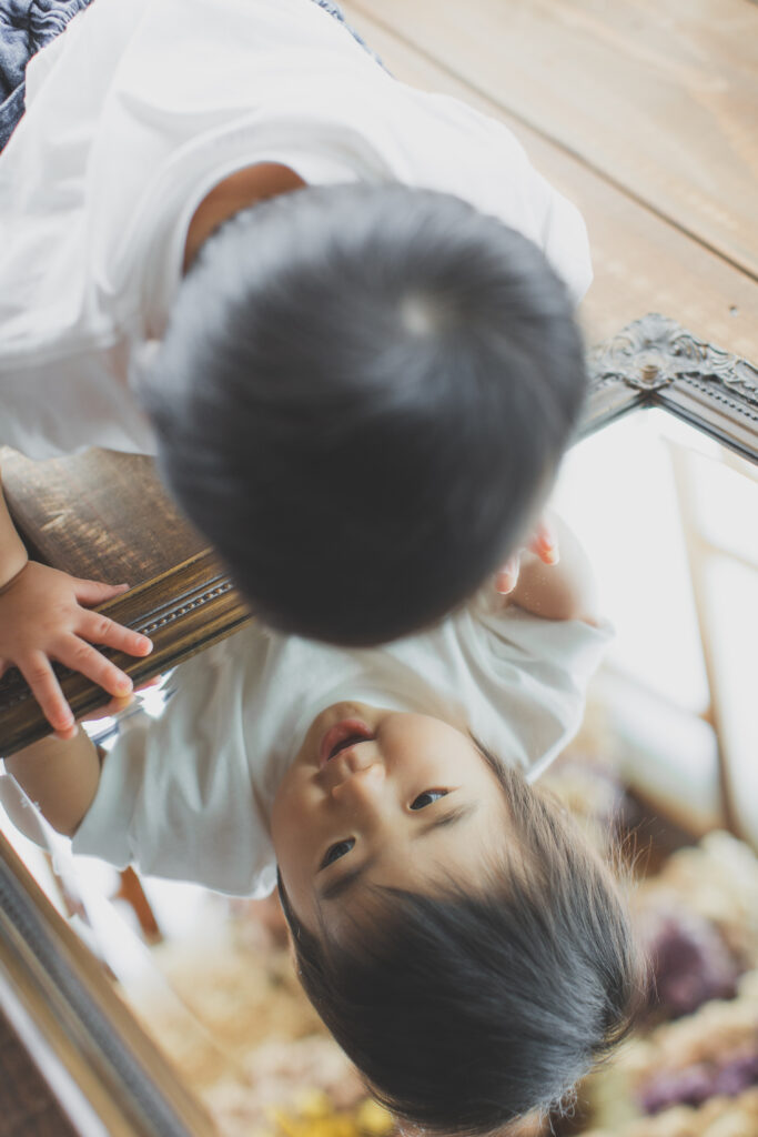 鏡を見て遊ぶ1歳の男の子