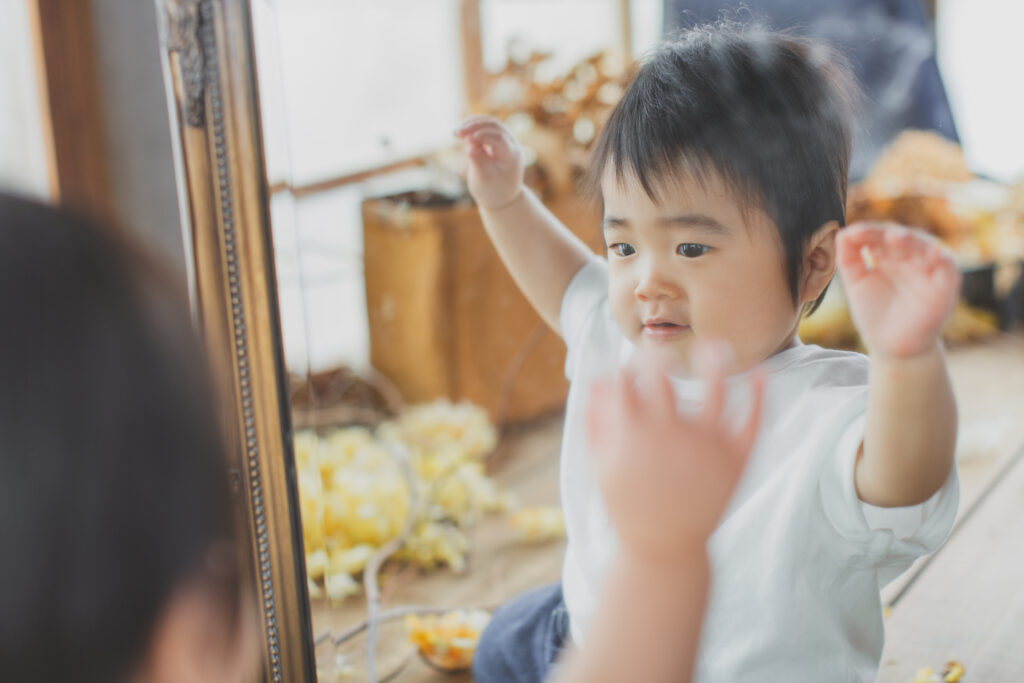 鏡を見て遊ぶ1歳の男の子