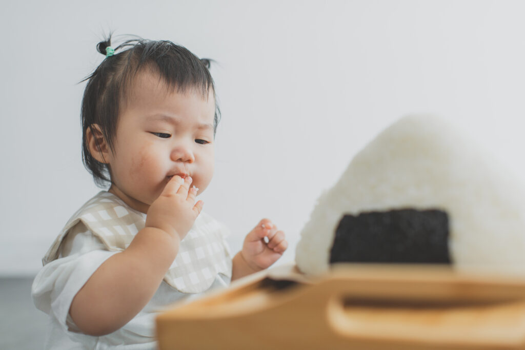 1歳のバースデーフォトで特大おにぎりと一緒に撮影