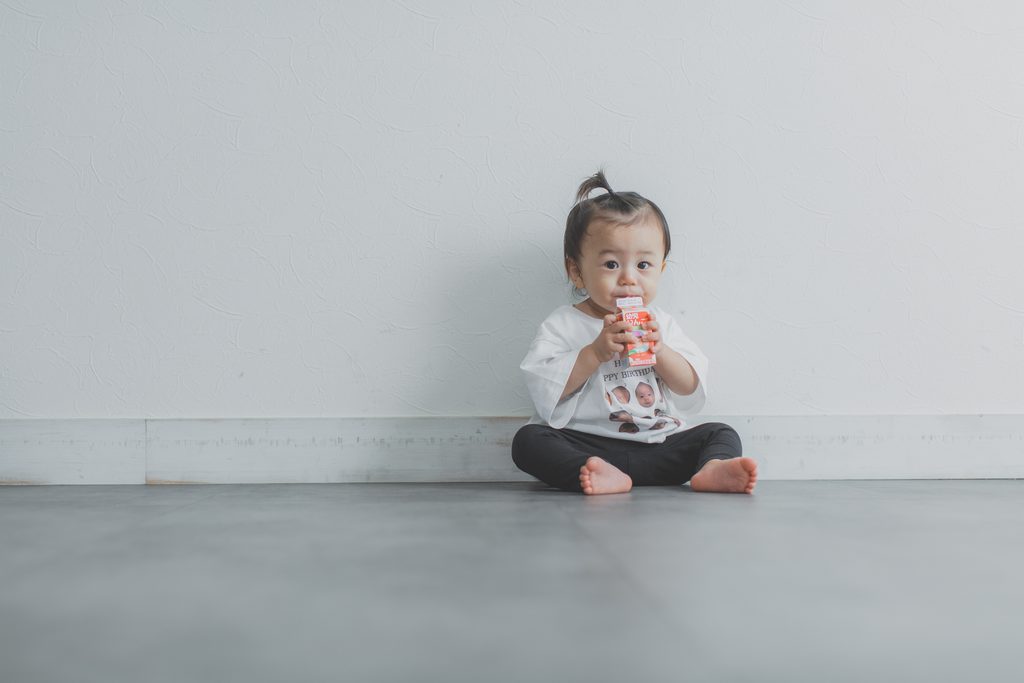 飲み物を飲んで休憩する1歳の男の子